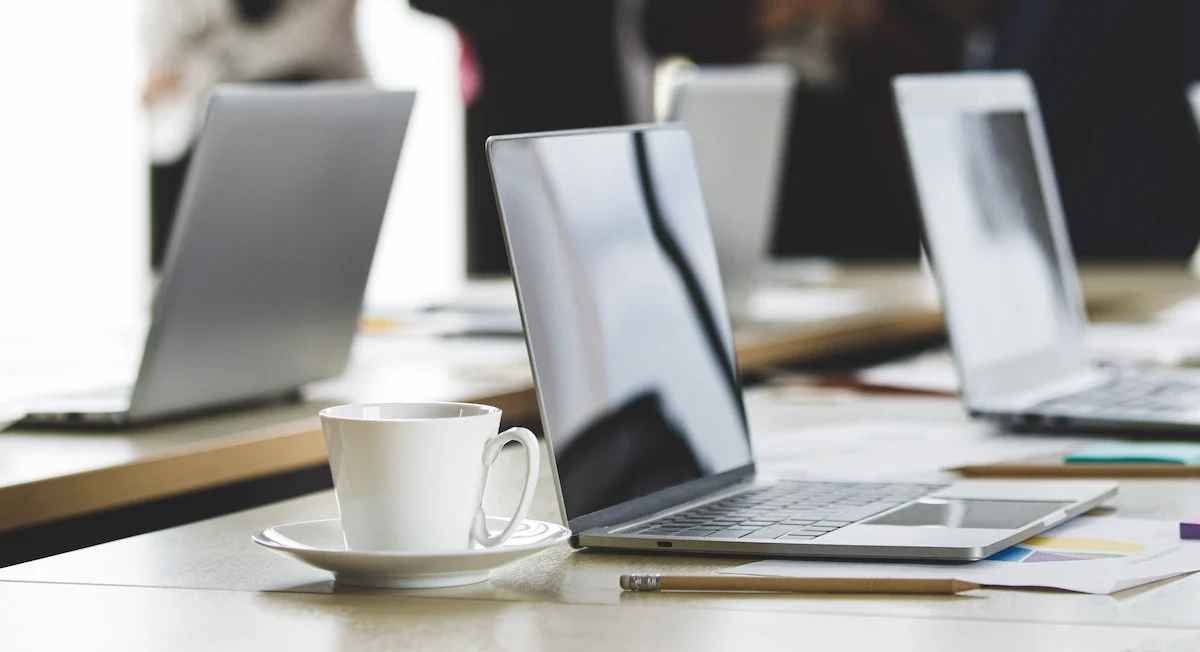 Deretan laptop siap pakai di meja meeting kantor — ilustrasi layanan sewa laptop dan komputer untuk perusahaan kawasan industri Cikarang Bekasi