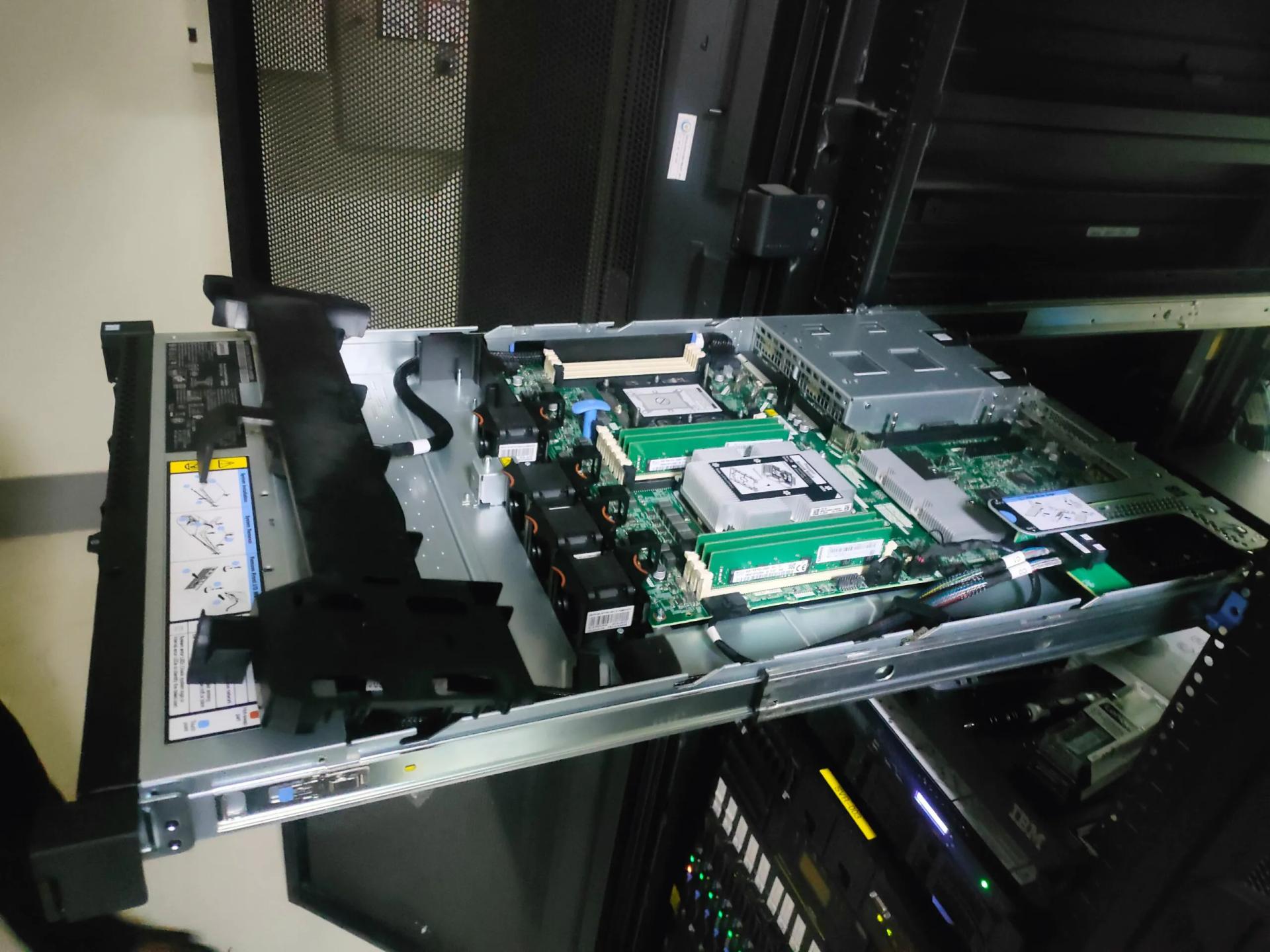 Server rack yang dibuka untuk maintenance — komponen motherboard, RAM, dan kabel power dalam kondisi tidak tertata sebelum dilakukan perapihan oleh tim IT Sastradinata