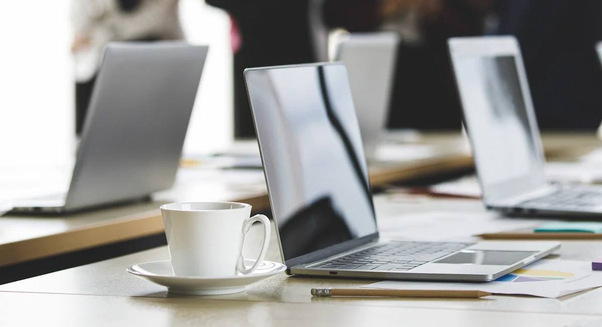 Deretan laptop siap pakai di meja meeting kantor — ilustrasi layanan sewa laptop dan komputer untuk perusahaan kawasan industri Cikarang Bekasi