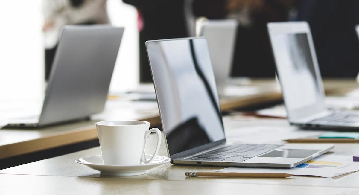 Laptop kerja di meja kantor dengan layar aktif — setiap unit perangkat kerja adalah titik yang perlu dilindungi dari ancaman siber