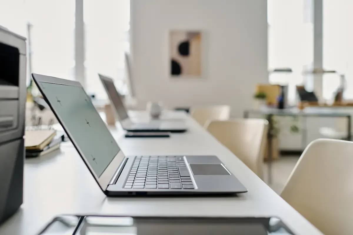 Laptop kerja karyawan tertata di ruang kantor modern — ilustrasi layanan endpoint security untuk melindungi perangkat kerja perusahaan kawasan industri Cikarang Bekasi
